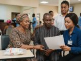 A patient and his wife review a document with a hospital staff member